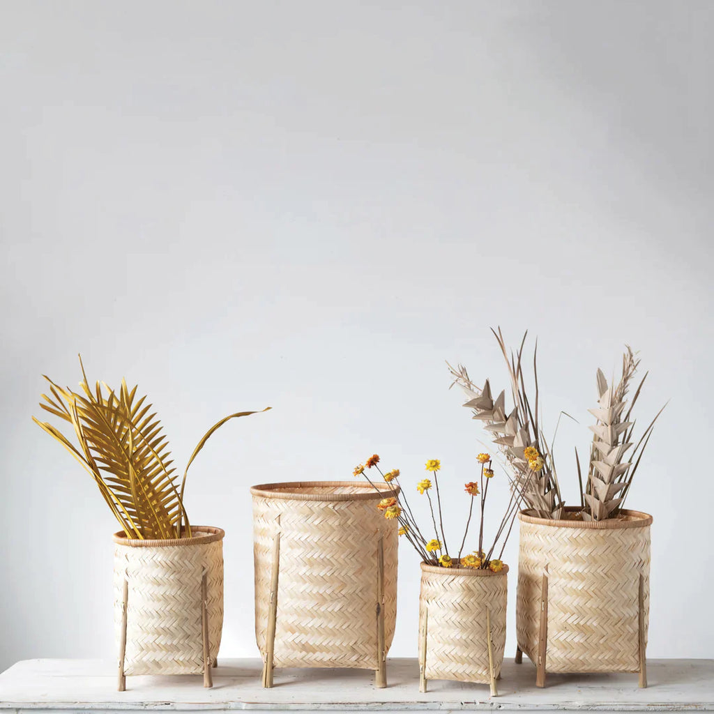 Baskets with dry floral arrangements in front of a grey wall