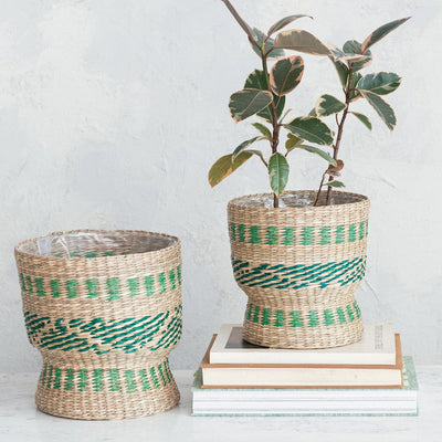 Baskets with dry floral arrangements in front of a grey wall