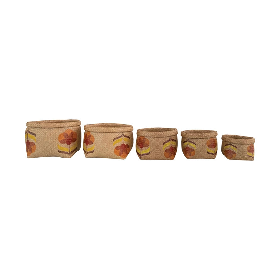 5 seagrass baskets with orange flowers and yellow leaves and rolled rim in a line from largest to smallest
