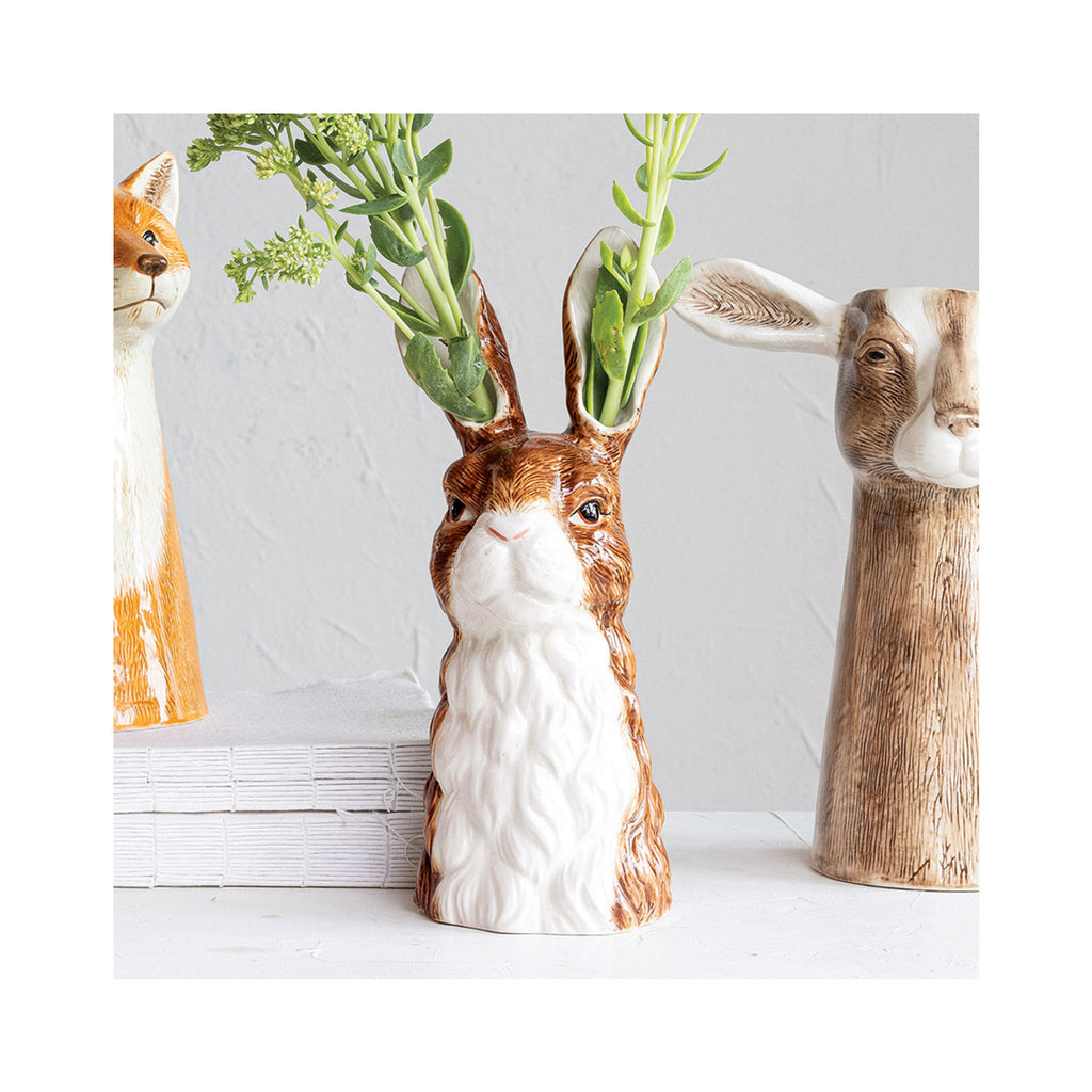 Hand-Painted Stoneware Rabbit Vase with holes in each ear decorated with greenery.