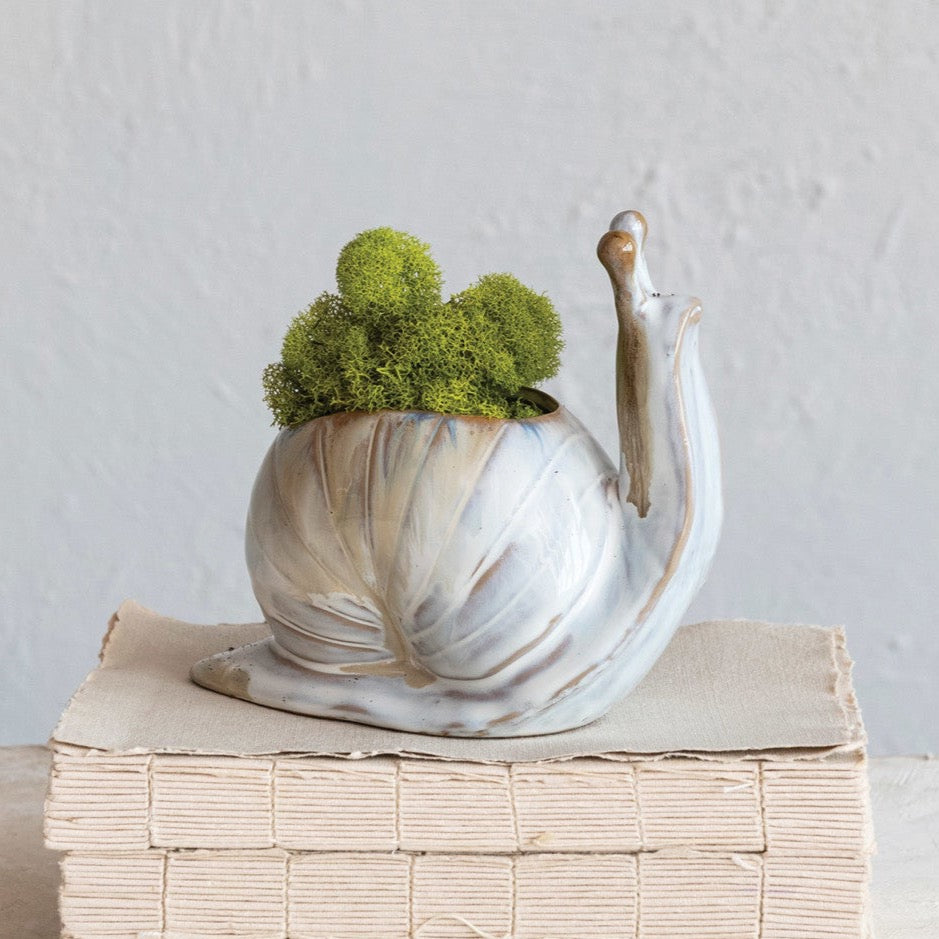 Stoneware Snail Vase shown with moss inside on books and white background