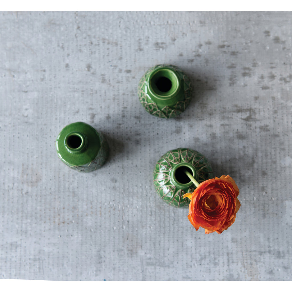 3 Green Embossed Stoneware Vases view from the top and orange ranunculus flower on grey table.