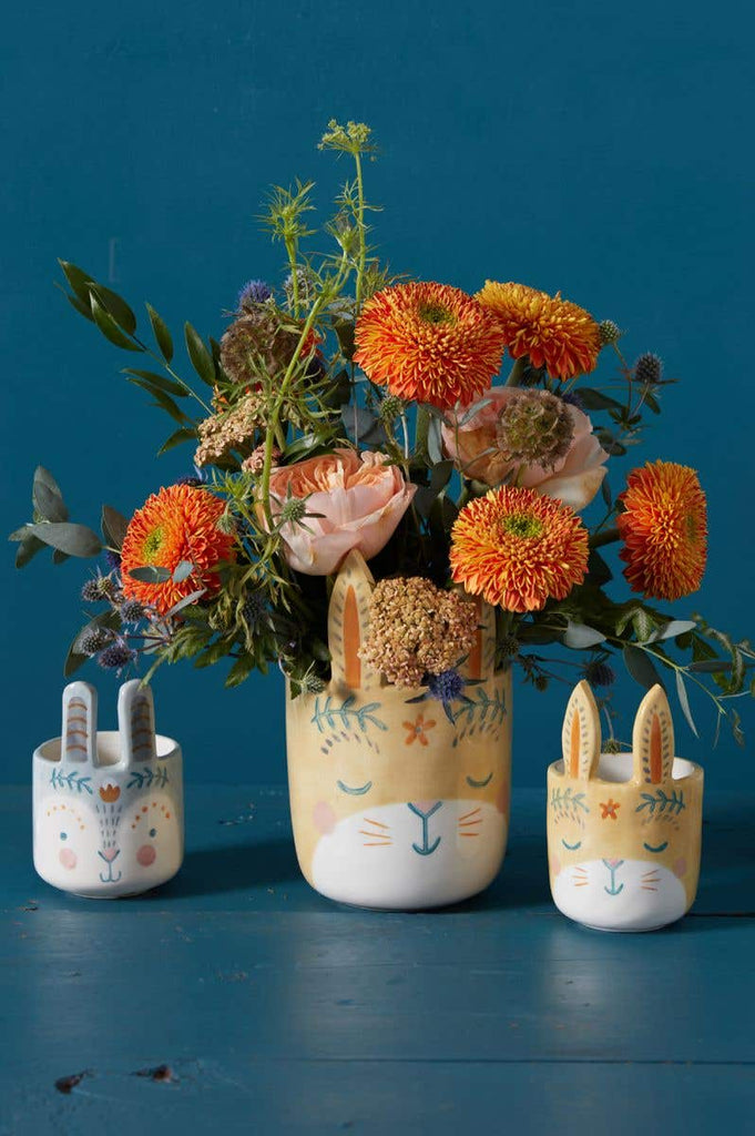 Frolic Bunny Pots in yellow and blue with flowers and blue background
